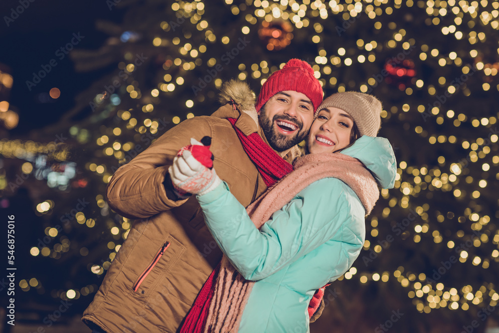 Sticker Photo of two funny excited people hold arms dancing have fun enjoy x-mas evening tree lights outdoors