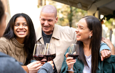 Happy friends toasting wine at bar dehor - Friendship lifestyle concept with young millennial people enjoying time together at open air cafe - Focus on central man