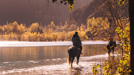 a groom on a horse walks on the lake