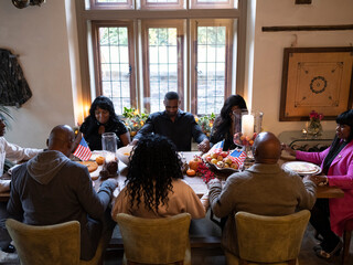 Family praying before Thanksgiving dinner