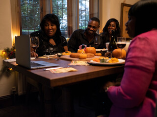 Family having video call during Thanksgiving dinner