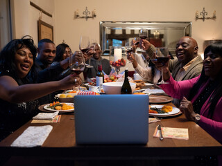 Family having video call and raising toast during Thanksgiving dinner