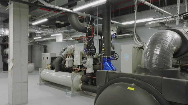 Central heating and cooling system installed with motor machine and pipelines in an industrial factory building