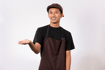Handsome barista asian man wearing brown apron and black t-shirt isolated over white background pointing with fingers. showing product recommendation advertising concept