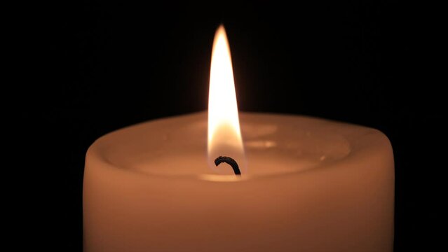 burning candle on the black backgrounds