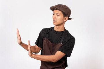 Handsome barista asian man wearing brown apron and black t-shirt isolated over white background...