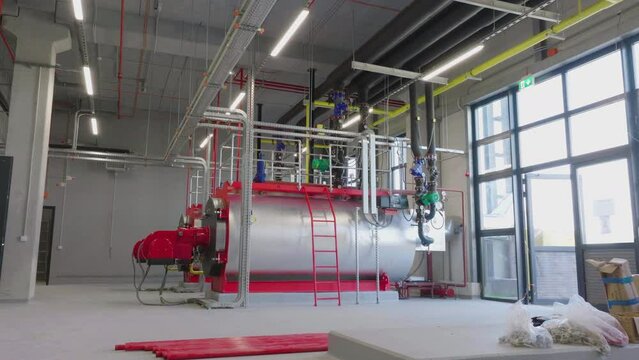 View of cooling system with large tank connected with pipelines in an industrial factory building