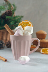 A cup of marshmallows with cinnamon, anise and dried oranges.
