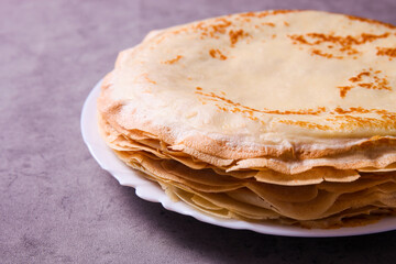 Stack of thin pancakes on plate