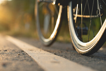 Road bike parked on a beautiful road sunset, warm light with copy space.