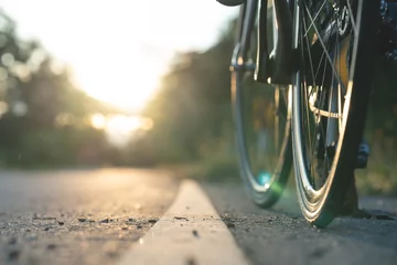 Papier Peint photo autocollant Vélo Road bike parked on a beautiful road sunset, warm light with copy space.