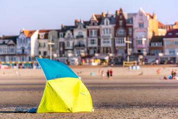 Scenic view of beach at sunset with beach umbrella and city view in the background