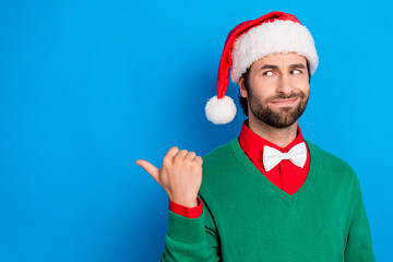 Photo of doubtful handsome man look direct thumb finger empty space hesitate isolated on blue color...