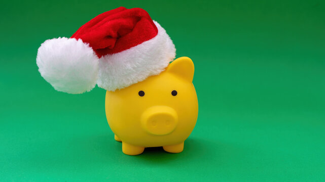 Christmas holiday Sale. Piggy bank with Santa hat isolated on green