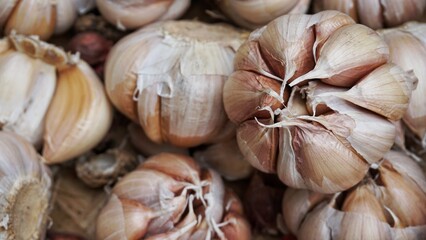A bunch of whole garlic bulbs in a container made of bamboo.