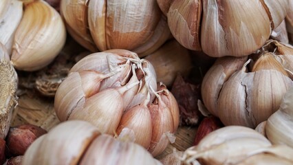 A bunch of whole garlic bulbs in a container made of bamboo.