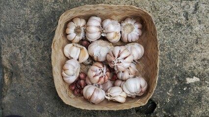 Whole garlic bulbs in a container made of bamboo.