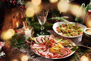 Christmas table with a platter of sliced ham and cured meat and salad