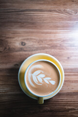 fresh tasty cappuccino or latte coffee with milky foam on wooden table in cafe