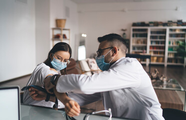 Male doctor examining female patient in clinic