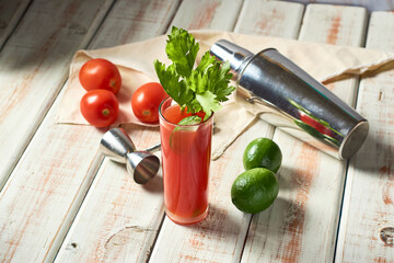 Bloody mary cocktail and ingredients on a wooden table, copy space