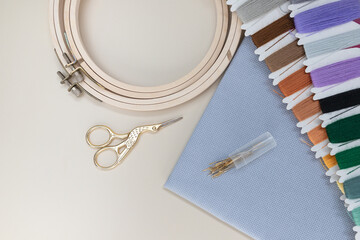 Accessories for embroidery: needles, set of colored mouline threads,  scissors and natural canvas,...