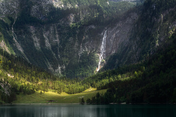 View of the Röthbach Waterfall falling from the mountain on the lake Obersee. Germany. Summer. German Alps. Tranquillity.