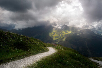 Mountain road in the Austrian mountains with clouds and sun rays. Stubnerkogel. Austria. Summer. Bad Gastein.