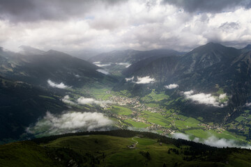 View of the small city Bad Gastein in the valley in the Austrian mountains with clouds and sun rays. Stubnerkogel. Austria. Summer. Bad Gastein.