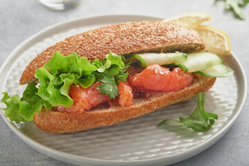 Sandwiches with salted salmon. Open sandwiches from cereal or whole grain rye bread with salted salmon, sesame seeds and dried tomato on white marble stand. Seafood. Healthy food. Scandinavian cuisine