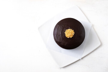 Vegan Chocolate Cake with Peanut Butter Filling, Covered with Chocolate Cream and Decorated with Small Pieces of Peanuts