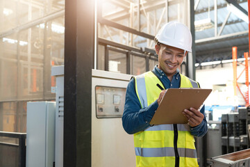 Portrait An Asian warehouse worker in a blue security suit holding clipboard working at store industry. Logistic import export concept Distribution Center. Logistics and export of business.