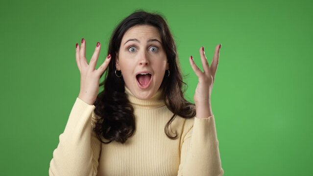 Slow motion portrait of excited, surprised smiling pretty young hipster woman 20s gives thumbs up smiling isolated on green screen background studio