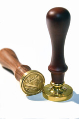 Two wax seal stamps with a wooden handle and a brass head. 