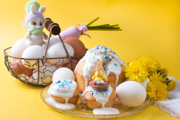 easter cake and eggs with flowers on a yellow background. The concept of the Easter party