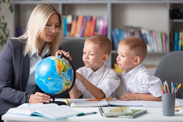 Fototapeta premium Teacher and children with globe, geography interesting learning.