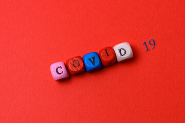 The inscription on the wooden cubes - covid - 19 on a red background.