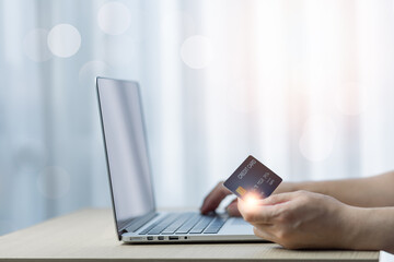 Hands holding credit card and using laptop. Online shopping