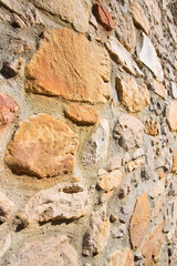 Old wall built with irregularly shaped stone blocks recently restored