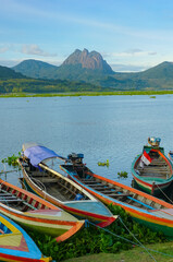 Fishing boats anchored on the banks of the Jatiluhur reservoir. Beautiful view with mountains in the background.