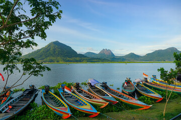 Fishing boats anchored on the banks of the Jatiluhur reservoir. Beautiful view with mountains in...