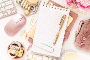 A femininely styled desktop in shades in gold and dusty pink with modem stationery. Lifestyle theme...