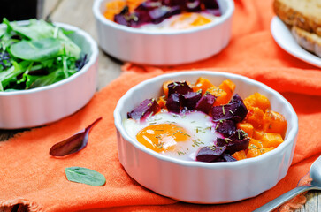 Beet Sweet potato baked eggs on a wood background