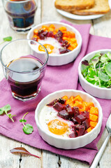 Beet Sweet potato baked eggs on a wood background