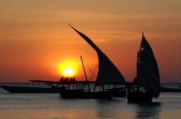 Photo sur Plexiglas Plage de Nungwi, Tanzanie Bateau de pêcheur au coucher du soleil, pris au village de Nungwi, île de Zanzibar, Tanzanie Nungwi. Nungwi est traditionnellement le centre de l& 39 industrie de la construction de boutres à Zanzibar.