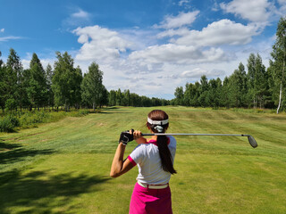 Woman holds golf club behind back closeup