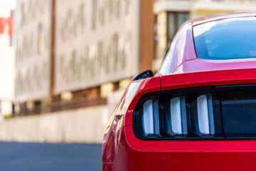 Rear view of a red muscle car taillights. Car parked in a residential area