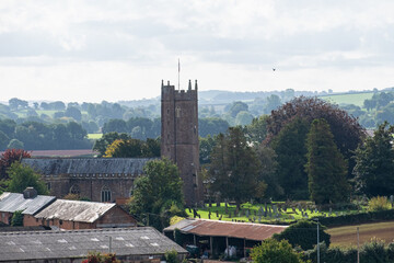 The parish church of St Andrew at Halberton village in mid Devon UK in early autumn. The red stone...