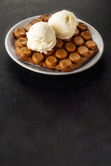 Hong Kong chocolate bubble waffle with ice cream on dark background with copy space.