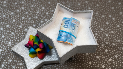 Swiss cash, Way to give money (swiss franc CHF) as a gift. Giving money as a gift. A monetary gift in a silver shiny star box, stars pattern, multicolour, rainbow bow 
